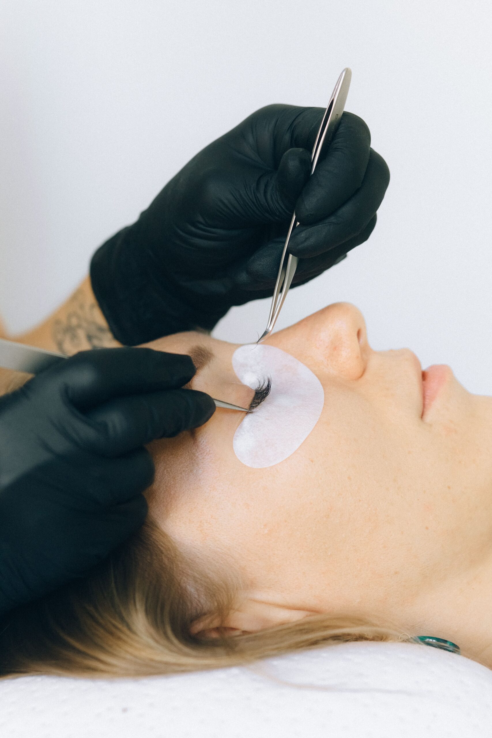 Cluster lash extensions — Beautician applying eyelash extensions to a client