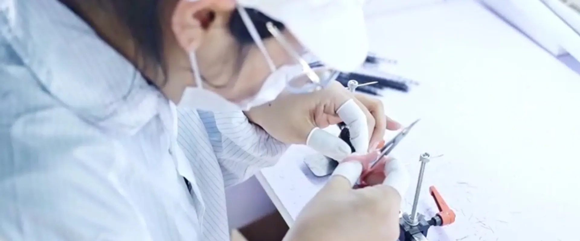 Lash extensions factory — Workers in protective suits inside a sterile cleanroom
