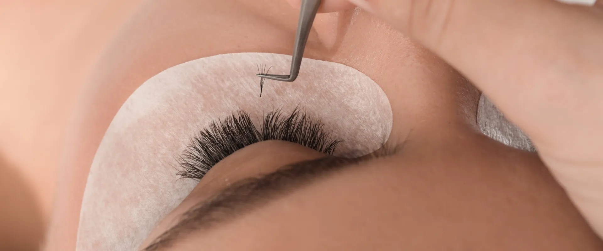 Lash bonder — Beauty product bottle on a warm orange background